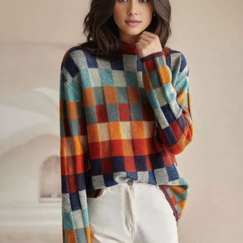 Modelka w swetrze damskim z półgolfem w kolorową kratę i białych spodniach